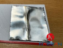 Detailní pohled na přesný laserový svar na tenkém nerezovém plechu.